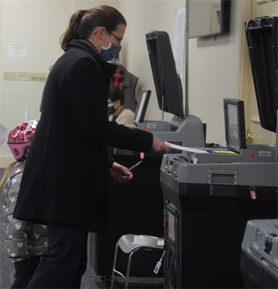 Woman voting at a polling location with a DS200 voting machine